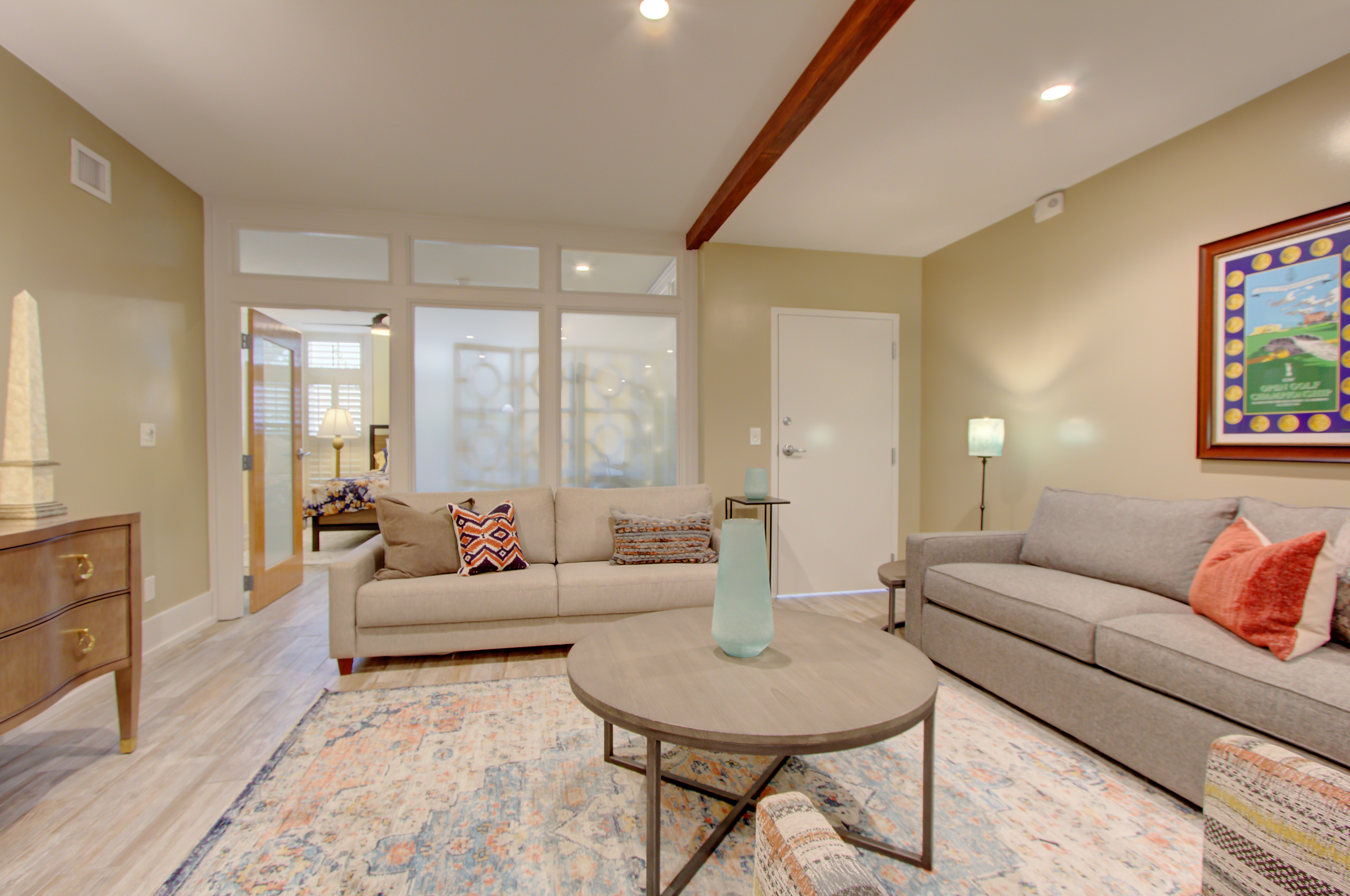 A wide view of a hotel lobby with two sofas, a coffee table, and artwork on the wall.